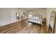 A light-filled bedroom with wood-look floors, a decorative wall, and a view into the dining area at 620 Jaxson Blvd, Winter Haven, FL 33880