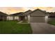 Inviting curb appeal of single-story home with a well-manicured lawn at sunset at 620 Jaxson Blvd, Winter Haven, FL 33880