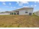 Home backyard view from the grass, showing the covered patio and home exterior at 622 Taft Dr, Davenport, FL 33837