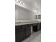 Elegant bathroom featuring dual sinks with granite countertops and dark wood cabinetry at 622 Taft Dr, Davenport, FL 33837