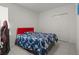 Bedroom with red headboard, blue comforter, tiled floors, and closet with white bi-fold doors at 622 Taft Dr, Davenport, FL 33837