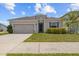 Single-story home with a two-car garage and a well-maintained lawn and trimmed landscaping at 622 Taft Dr, Davenport, FL 33837