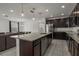 Stylish kitchen featuring granite counters, stainless appliances, dark cabinets, and an island at 622 Taft Dr, Davenport, FL 33837