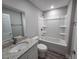 Bathroom with tub and shower, granite countertop, and modern fixtures at 628 Se Pine Ave, Fort Meade, FL 33841