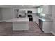 Kitchen showcasing an island, granite counters, stainless appliances, white cabinets, and wood-look floors at 628 Se Pine Ave, Fort Meade, FL 33841