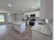 Kitchen featuring granite counters, stainless steel appliances, white cabinets, and wood-look flooring at 628 Se Pine Ave, Fort Meade, FL 33841