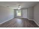 Bright living room featuring wood-look floors, ceiling fan, a large window, and a freshly painted interior at 628 Se Pine Ave, Fort Meade, FL 33841