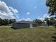 The rear exterior showcases the home's backyard with clear blue skies at 628 Se Pine Ave, Fort Meade, FL 33841