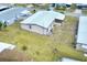 Aerial view of home featuring a metal roof, screened lanai, and spacious yard at 6470 Peppertree Ne Path, Winter Haven, FL 33881