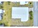 Aerial view of home featuring a metal roof, surrounding lawn and mature landscaping at 6470 Peppertree Ne Path, Winter Haven, FL 33881
