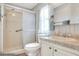 Well-lit bathroom featuring a walk-in shower, toilet, sink, and elegant marble countertops at 6470 Peppertree Ne Path, Winter Haven, FL 33881
