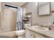 Bathroom with a shower and tub, toilet, vanity with a sink and patterned wallpaper at 6470 Peppertree Ne Path, Winter Haven, FL 33881