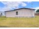Shows side of house with cream colored vinyl siding, and maintained lawn surrounding the manufactured home at 6470 Peppertree Ne Path, Winter Haven, FL 33881