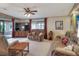 Cozy living room featuring a ceiling fan, comfortable seating, and access to the screened patio at 6470 Peppertree Ne Path, Winter Haven, FL 33881