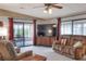 Inviting living room featuring a ceiling fan, comfortable seating, and access to the lanai at 6470 Peppertree Ne Path, Winter Haven, FL 33881