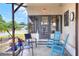 Inviting front patio with outdoor seating, tiled floor, and a view of the landscaped front yard at 6470 Peppertree Ne Path, Winter Haven, FL 33881