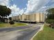 Low-rise condo building with parking under the building on a sunny day at 700 Mirror Nw Ter # 303, Winter Haven, FL 33881