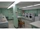 This laundry room has rows of washing machines and some folding tables at 700 Mirror Nw Ter # 303, Winter Haven, FL 33881