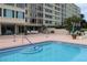 Inviting pool area features well-maintained brick decking, stylish outdoor seating, and lush landscaping at 700 Mirror Nw Ter # 303, Winter Haven, FL 33881