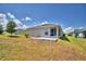 An exterior shot shows a home's backyard with a small patio and simple landscaping under a partly cloudy sky at 710 Persian Dr, Haines City, FL 33844