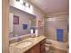 This bathroom has a granite countertop, wood cabinets, and a shower/tub combo with a blue accent lighting at 710 Persian Dr, Haines City, FL 33844