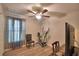 Well-lit room with ceiling fan, wood-look flooring, a chair, a desk and an exercise bike at 710 Persian Dr, Haines City, FL 33844
