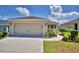 This home features an attached two-car garage with manicured flower beds, lawn and landscape along the driveway at 710 Persian Dr, Haines City, FL 33844