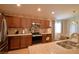 Kitchen with wood cabinets, stainless steel appliances and granite countertops at 710 Persian Dr, Haines City, FL 33844