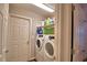 The laundry room has a washer, dryer, storage shelves, and white doors for easy access and convenience at 710 Persian Dr, Haines City, FL 33844