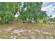 Large backyard featuring a wooden fence, trees, and ample open space for outdoor activities at 780 Oleander Se Dr, Winter Haven, FL 33880