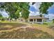 Backyard with a grassy lawn, shaded by trees, offers a serene outdoor space at 780 Oleander Se Dr, Winter Haven, FL 33880