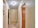 Neutral hallway showcasing tiled floors and multiple doorways leading to various rooms in the house at 780 Oleander Se Dr, Winter Haven, FL 33880