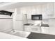 Galley kitchen features white appliances, tile backsplash, and sleek countertops at 900 Avenue Z Se # B2, Winter Haven, FL 33880