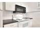 Updated kitchen featuring stove, black microwave, tile backsplash, and sleek countertops at 900 Avenue Z Se # B2, Winter Haven, FL 33880