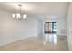 Bright living room with tile flooring, ceiling fan, chandelier, and sliding glass doors at 900 Avenue Z Se # B2, Winter Haven, FL 33880