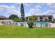 Community pool with chairs, tables and shade umbrellas in a manicured, green lawn area at 900 Avenue Z Se # B2, Winter Haven, FL 33880