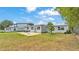 Spacious backyard with a patio, lush green grass, and a white house at 900 Lake Jessie Dr, Winter Haven, FL 33881