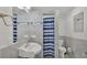 Updated bathroom featuring gray tile, a blue-striped shower curtain, and modern fixtures at 900 Lake Jessie Dr, Winter Haven, FL 33881