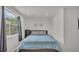 Cozy bedroom with a blue blanket, a large window and neutral colored walls at 900 Lake Jessie Dr, Winter Haven, FL 33881