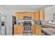 Kitchen with stainless steel appliances, wooden cabinets, and dark countertops at 900 Lake Jessie Dr, Winter Haven, FL 33881