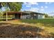 A lush green lawn with mature trees surrounds a screened-in porch and carport at 1003 Bear Lake Rd, Apopka, FL 32703