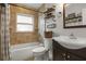 Bright bathroom features neutral tile surround, a single sink vanity, and decorative shelving at 1003 Bear Lake Rd, Apopka, FL 32703
