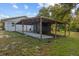 A view of the carport and back of the home on a lush green lawn at 1003 Bear Lake Rd, Apopka, FL 32703