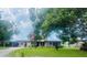 Charming single-story home with a lush green lawn, mature trees, and an American flag proudly displayed at 105 Leslie Ave, Winter Haven, FL 33880