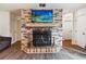 Inviting living room features a brick fireplace with rustic wood mantle and TV at 105 Leslie Ave, Winter Haven, FL 33880
