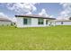 Well-kept backyard featuring a covered patio and a sprawling lawn, perfect for outdoor gatherings at 1050 Michelangelo Ln, Winter Haven, FL 33884
