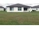 Large grassy backyard with a view of the home's exterior, and surrounding properties at 1050 Michelangelo Ln, Winter Haven, FL 33884