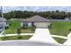 Exterior view of home featuring a two-car garage, well-kept lawn, and landscaped garden at 1050 Michelangelo Ln, Winter Haven, FL 33884