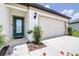 Home featuring a two-car garage, covered entry, and manicured landscaping at 1050 Michelangelo Ln, Winter Haven, FL 33884