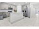 Open concept kitchen with stainless appliances, light gray cabinets, and an island with breakfast bar at 1050 Michelangelo Ln, Winter Haven, FL 33884